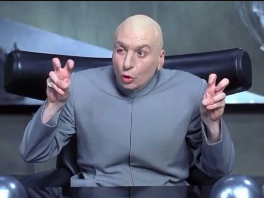 Dr. Evil from Austin Powers making his signature small hand gesture near his mouth.